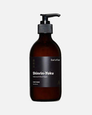 An amber glass hand wash bottle with a black pump dispenser and a black label reading 'Shinrin-Yoku' and 'Earl of East', photographed on a clean white background.