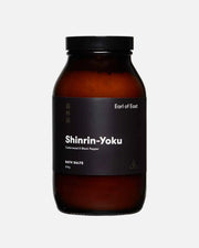 An amber glass jar of Shinrin-Yoku bath salts by Earl of East, featuring a black label and a black screw cap, set against a plain white background.