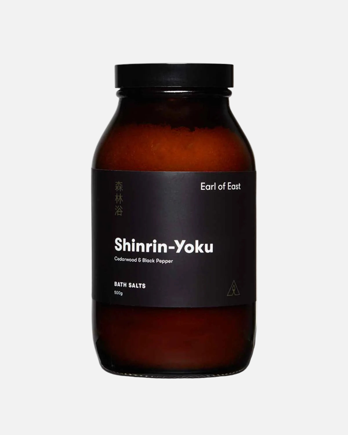 An amber glass jar of Shinrin-Yoku bath salts by Earl of East, featuring a black label and a black screw cap, set against a plain white background.