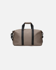 Beige duffel bag with black straps on a light gray background
