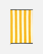 A rectangular striped towel or blanket with alternating mustard yellow and cream vertical stripes, finished with black trim at the top and bottom, shown flat against a white background.