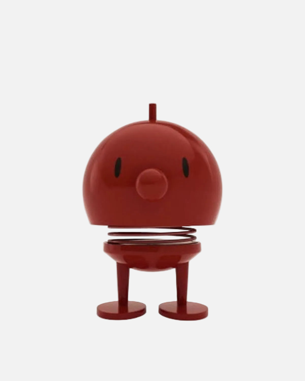 A red spring toy figure with a round head, simple black eyes, a protruding top stem, and two short legs on a plain white background.