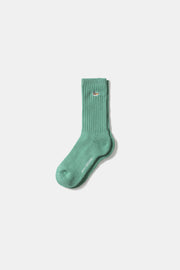 Green sock with a brand logo on a white background