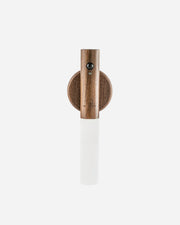 Wall-mounted light fixture with wooden base and white cylindrical shade on a white background