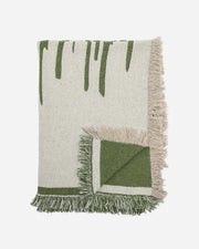 Green and beige woven blanket with fringes on a white background