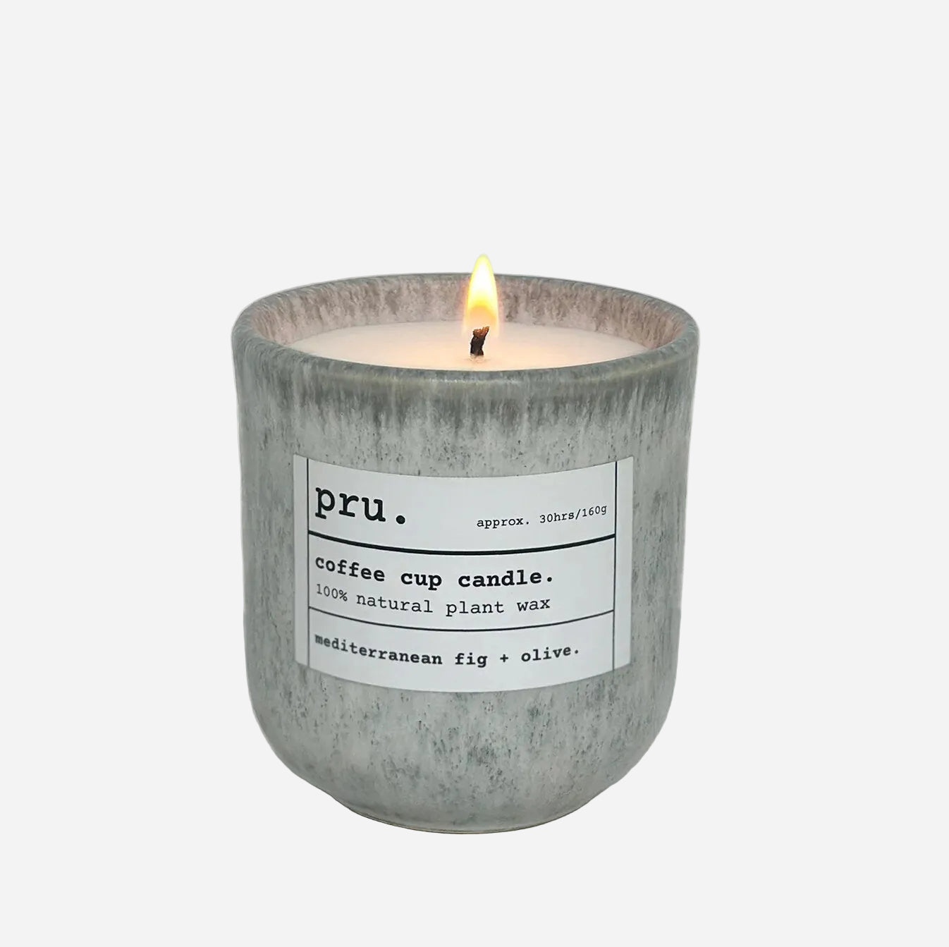 Candle in a concrete holder with a label on a light gray background