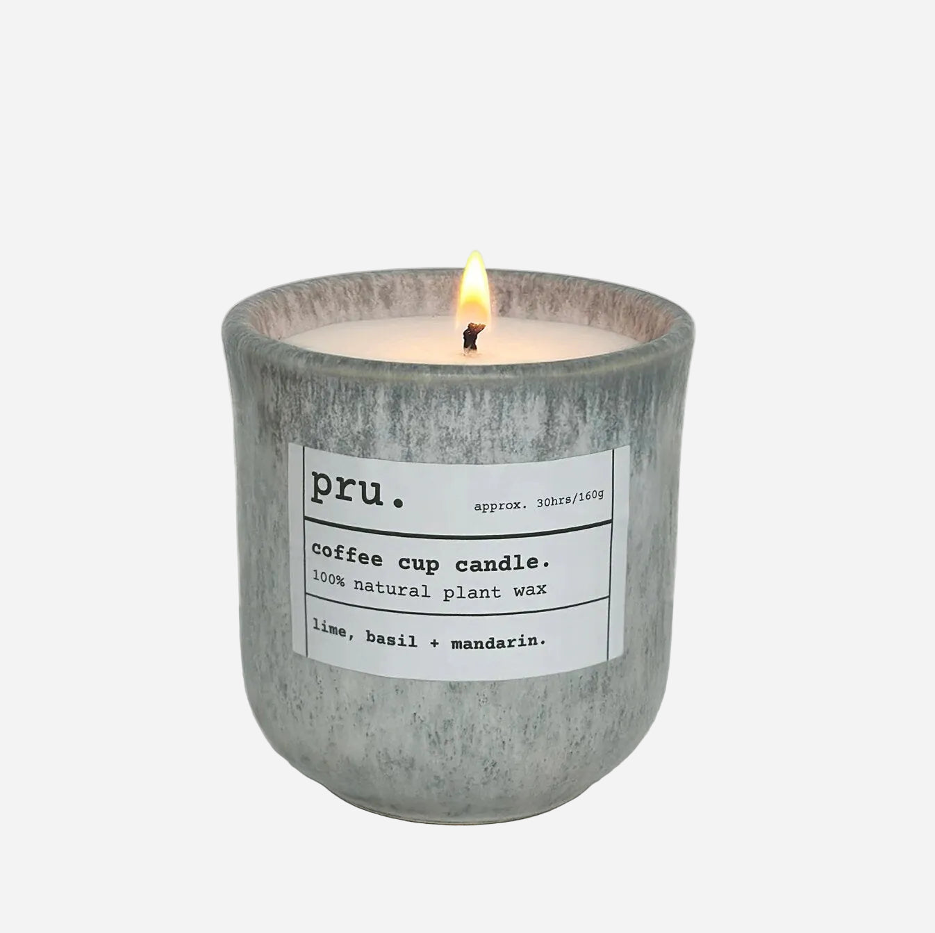 Candle in a textured container with a label on a light gray background