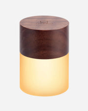 Wooden cylindrical lamp with a warm glow on a white background